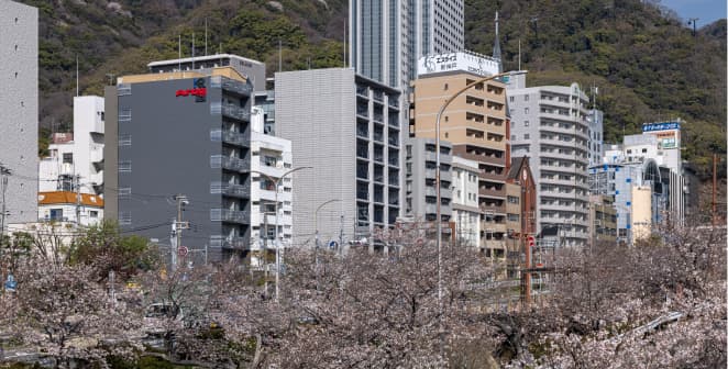 桜と街並み越しに見るK・R三宮イースト