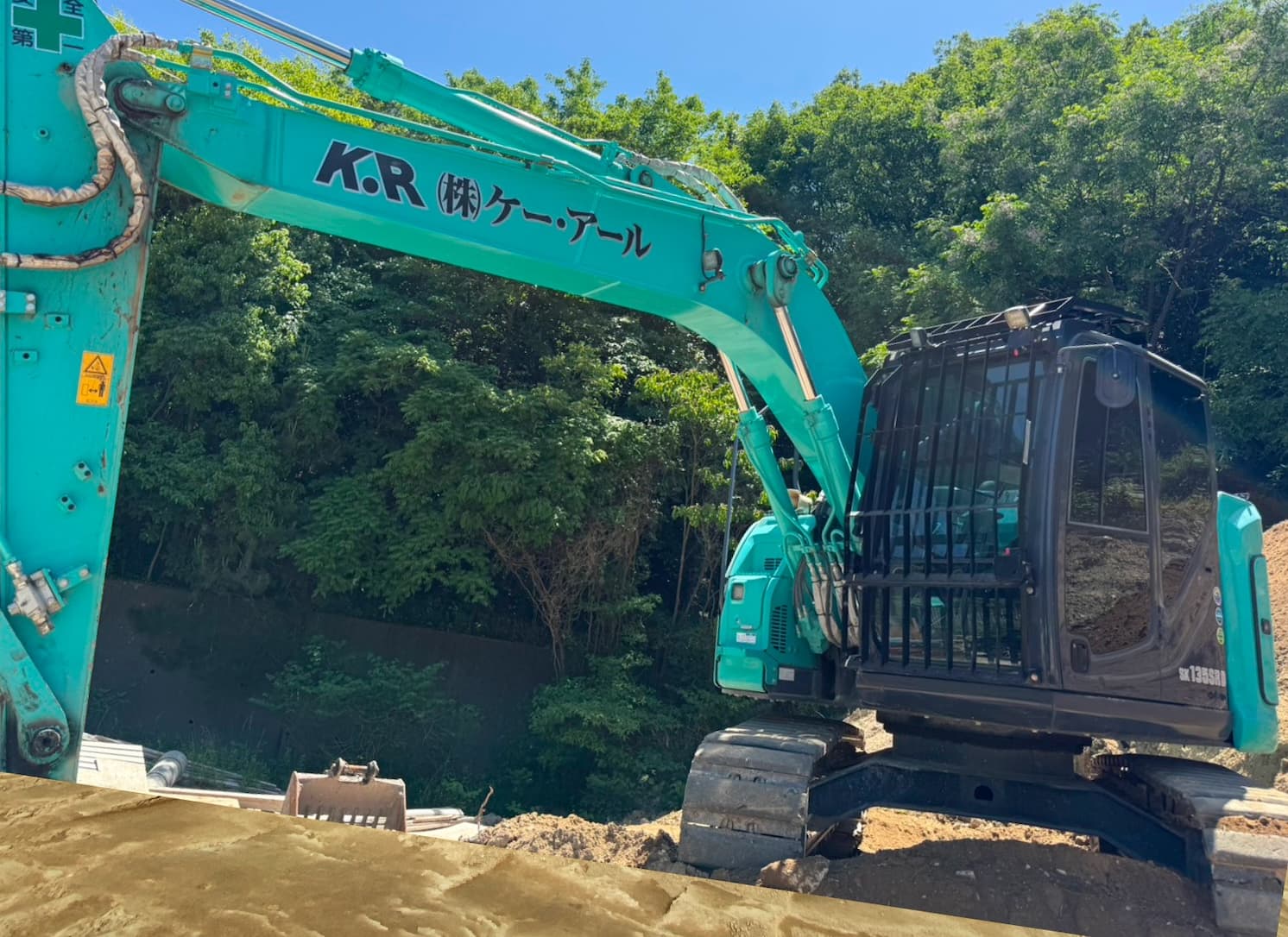 K・Rの社名ロゴが入った緑色の重機